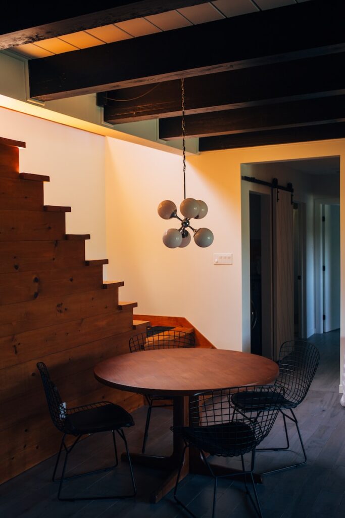 round brown wooden table and chairs under white pendant lamp